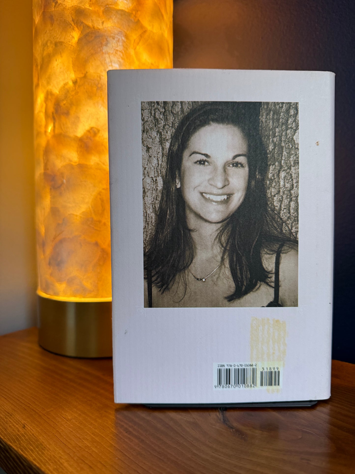 Book with a photo of a woman on its cover, illuminated by a warm lamp.