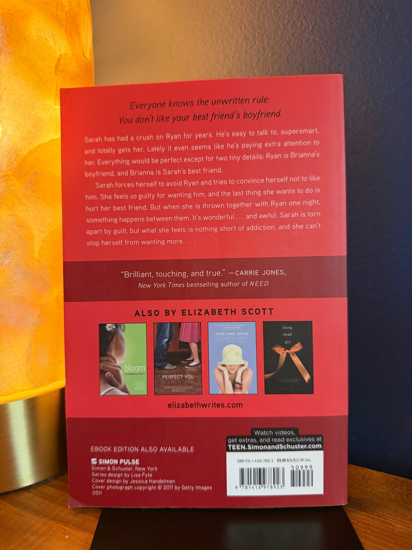 Back cover of a book with text and a barcode on a wooden surface