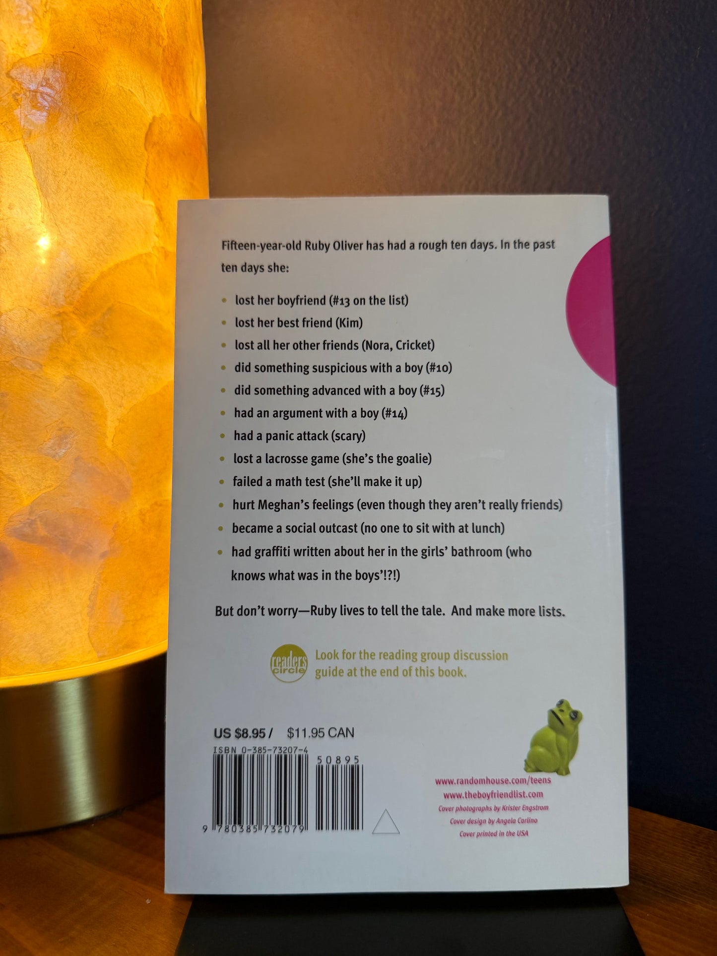 Back cover of a book with text and a barcode on a wooden surface.