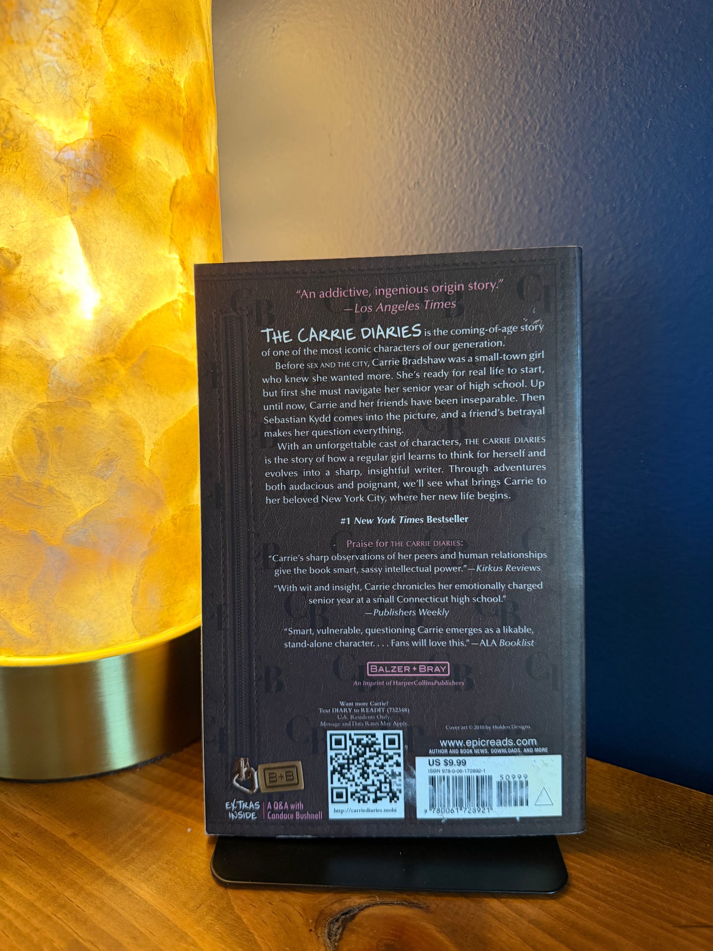 Back cover of a book with text and a QR code on a wooden surface.
