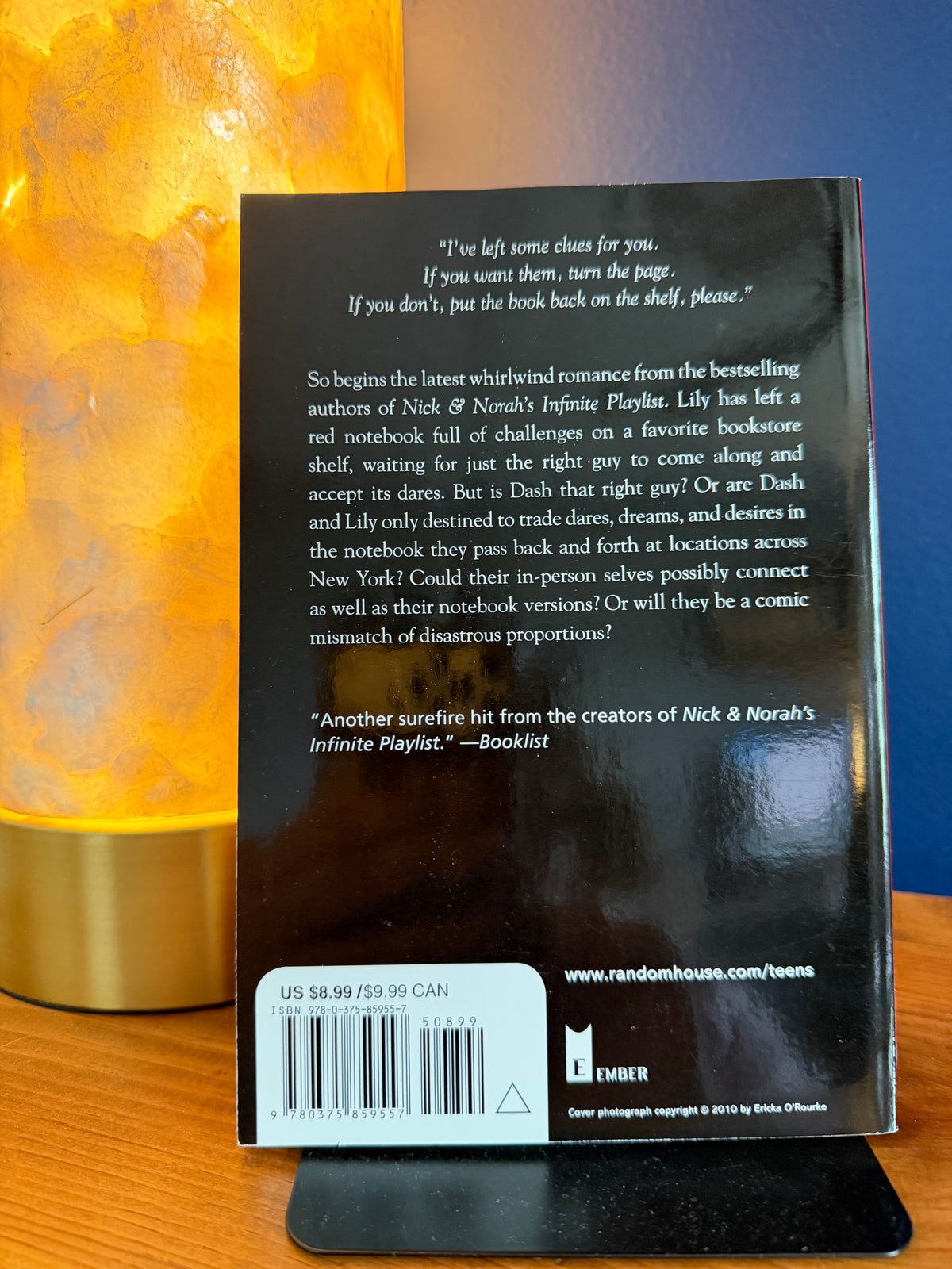Back cover of a book with text and a barcode on a wooden surface.