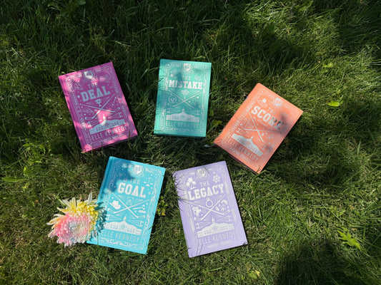 Off-Campus series by Elle Kennedy, all five special edition hardcovers (The Deal, The Mistake, The Score, The Goal, The Legacy) arranged on grass with a flower.