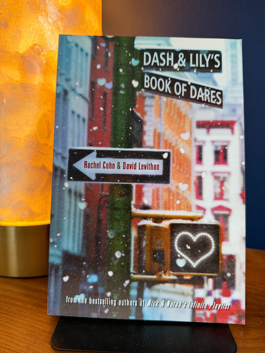 Book titled 'Dash & Lily's Book of Dares' on a stand with a colorful background