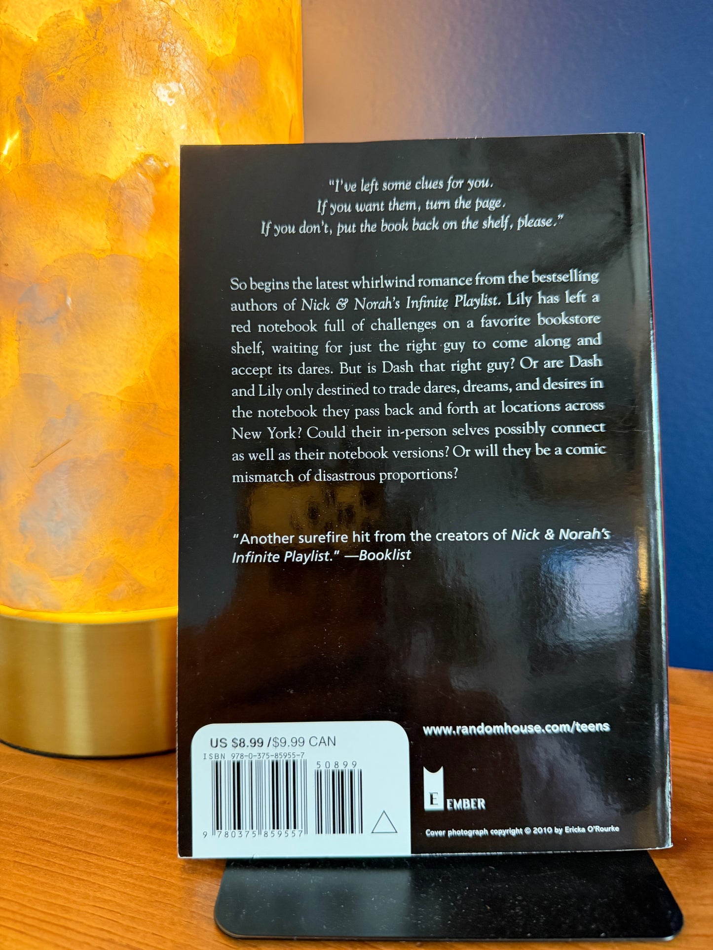 Back cover of a book with text and a barcode on a wooden surface.